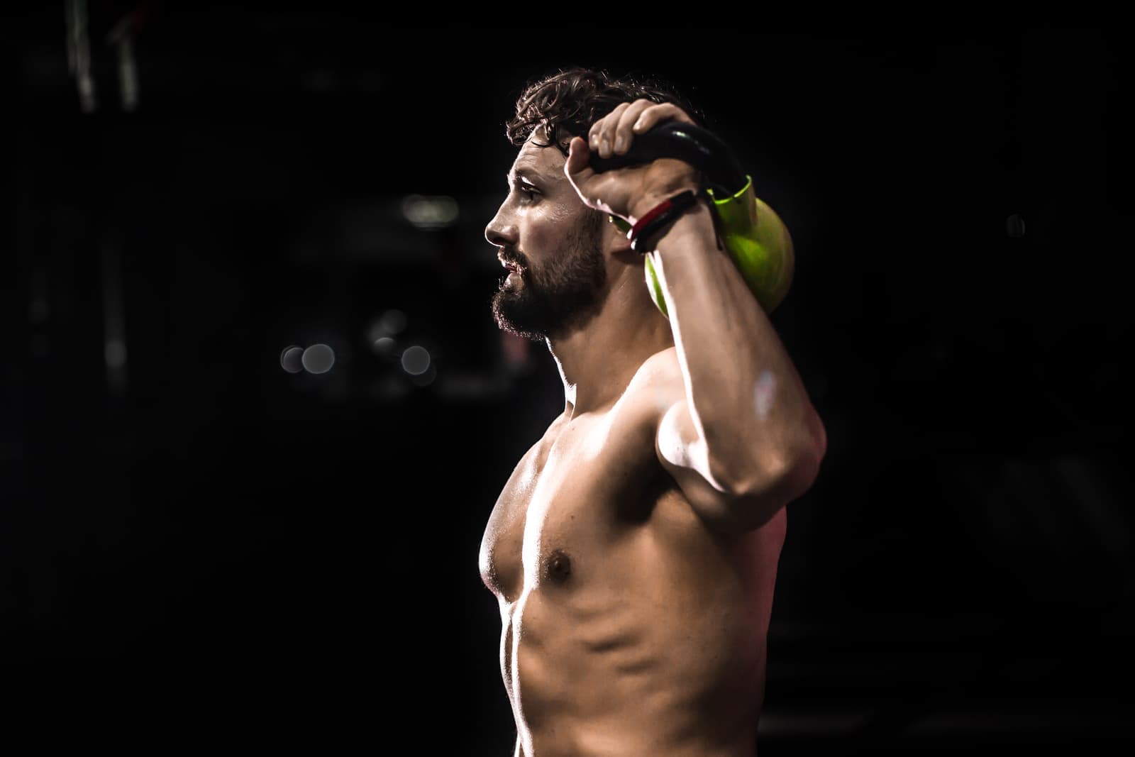 Illustration, un athlète soulève un kettlebell au-dessus de son épaule