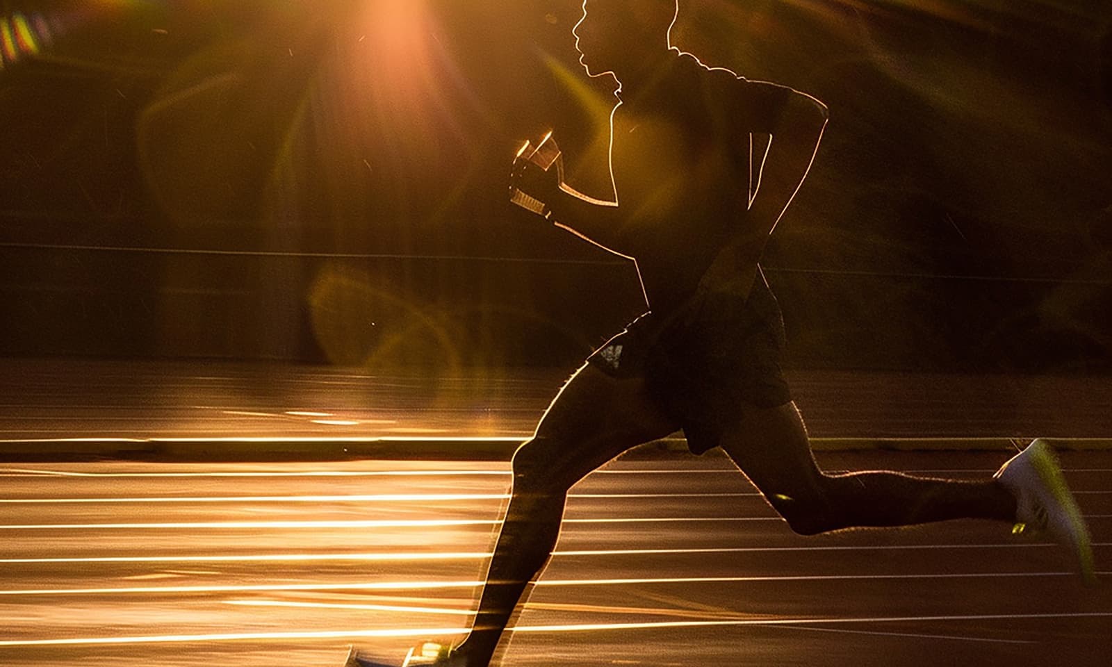 Illustration, un coureur lancé sur une piste dans la lumière du soir